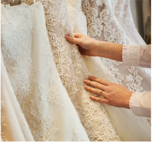 A picture of hands touching a wedding dress, showcasing Wedding Dresses in Hampshire